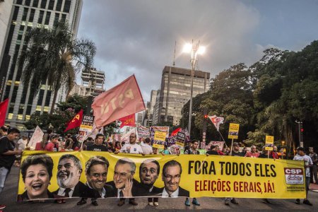 Photo for Brazil, Sao Paulo - April 1, 2016: Protesters hold signs reading All of them out! as hundreds of people demonstrate for the impeachment of President Dilma Rousseff and early elections at Avenida Paulista in Sao Paulo, southern Brazil - Royalty Free Image