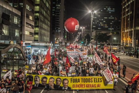 Photo for Brazil, Sao Paulo - April 1, 2016: Protesters hold signs reading All of them out! as hundreds of people demonstrate for the impeachment of President Dilma Rousseff and early elections at Avenida Paulista in Sao Paulo, southern Brazil - Royalty Free Image