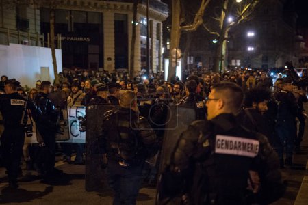 Foto de FRANCIA, París: Los policías franceses se enfrentan a los manifestantes durante una manifestación nocturna frente a una estación de policía en el segundo distrito de París, el 12 de abril de 2016. Manifestantes reclaman la liberación de un estudiante arrestado ese mismo día. - Imagen libre de derechos