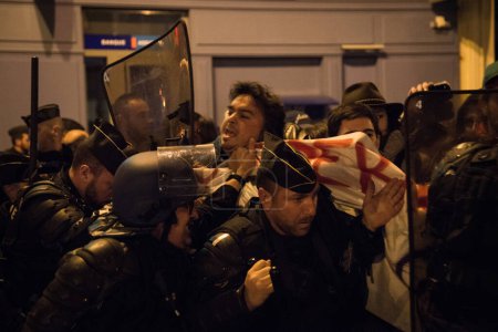 Téléchargez les photos : FRANCE, Paris : Des policiers français font face à des manifestants lors d'une manifestation nocturne devant un poste de police dans le 2e arrondissement de Paris, le 12 avril 2016. Des manifestants réclament la libération d'un étudiant arrêté plus tôt dans la journée. - en image libre de droit