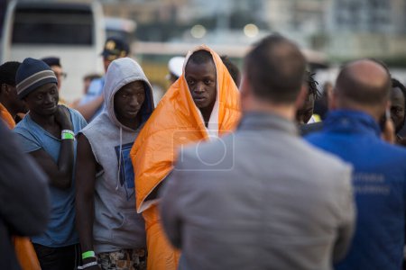 Photo for Italy, Palermo - April 13, 2016: Migrants and refugees mostly from North Africa disembark from Siem Pilot, a Norwegian-flagged ship taking part in the Frontex mission in Palermo harbour, in Sicily - Royalty Free Image