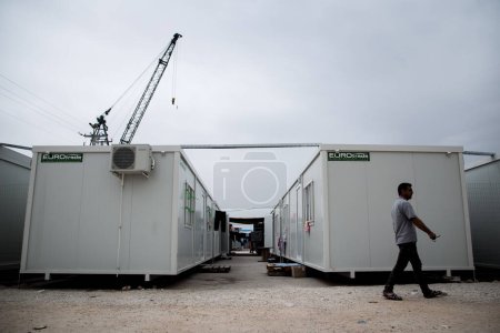 Photo for GREECE, Skaramagas: As thousands of refugees remain stranded in Greece, a family sits in one of several storage containers serving homes for 1,000 people at a new camp in Skaramagas, near Athens on April 14, 2016. - Royalty Free Image