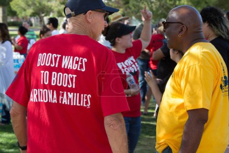 Photo for UNITED STATES, Phoenix: Protesters hold signs as hundreds of workers and supports took to the streets in Phoenix, Arizona on April 14, 2016 to call for a national minimum wage increase to an hour. - Royalty Free Image