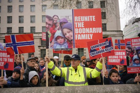 Foto de REINO UNIDO, Londres: Manifestantes sostienen pancartas que dicen: Los niños pertenecen a la familia o Noruega, devuelven a los niños a la familia Bodnariu durante una manifestación para condenar el secuestro legal en Noruega, en Londres, Reino Unido, el 16 de abril de 2016. - Imagen libre de derechos