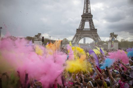 Téléchargez les photos : France : Un volontaire lance des pigments colorés sur les participants de la Color Run by Sephora à Paris le 17 avril 2016 - en image libre de droit