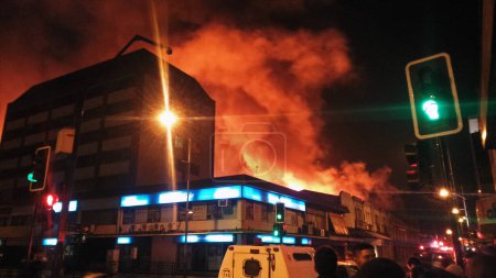 Foto de CHILE, Temuco: A massive fire hits the municipal market of Temuco, in the Cautin province, southern Chile, on the evening of April 20, 2016. - Imagen libre de derechos
