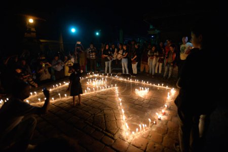 Téléchargez les photos : NEPAL, Patan : Des habitants du Népal se rassemblent pour allumer des bougies lors d'une veillée pour marquer le premier anniversaire d'un tremblement de terre dévastateur sur la place Durbar à Patan, dans la vallée de Katmandou, le 24 avril 2016 - en image libre de droit