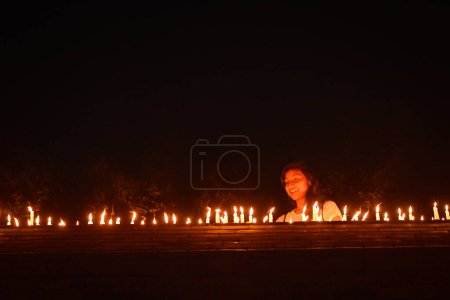 Foto de NEPAL, Patan: Los residentes nepaleses se reúnen para encender velas durante una vigilia para conmemorar el primer aniversario de un devastador terremoto en la plaza Durbar en Patan, valle de Katmandú, el 24 de abril de 2016 - Imagen libre de derechos