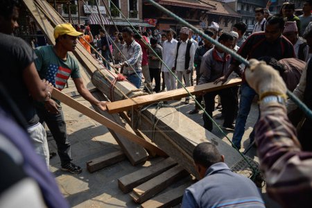 Téléchargez les photos : NEPAL, Katmandou : Des hommes commencent à reconstruire des sites patrimoniaux endommagés par le tremblement de terre il y a un an, le 25 avril 2016, sur la place Patan Durbar à Katmandou, au Népal, lors du premier anniversaire du tremblement de terre - en image libre de droit