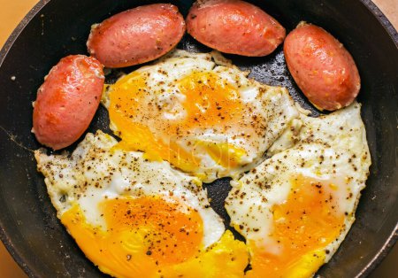 Foto de Huevos fritos con salchicha, tocino para el desayuno - Imagen libre de derechos