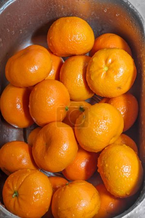 Photo for Tangerines washed, Wash fresh mandarins in retro colander - Royalty Free Image