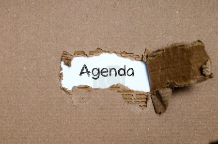 Foto de La palabra agenda que aparece detrás del papel roto - Imagen libre de derechos