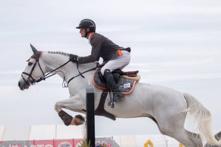 Téléchargez les photos : VILAMOURA, PORTUGAL - APRIL 3, 2016: Horse obstacle jumping competition - en image libre de droit