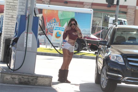 Foto de Ana Braga la brasileña Playboy Playmate manchado con pantalones cortos diminutos y conseguir gas, Studio City, CA - Imagen libre de derechos