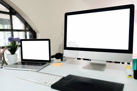 Téléchargez les photos : "Ordinateur portable et ordinateur PC de bureau sur la table de bureau avec espace vide - en image libre de droit