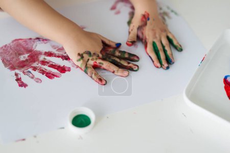 Foto de Pequeña chica asiática pintura con pincel y pinturas de colores - Imagen libre de derechos