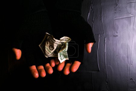 Téléchargez les photos : Homme avec un argent dans la chambre noire - en image libre de droit