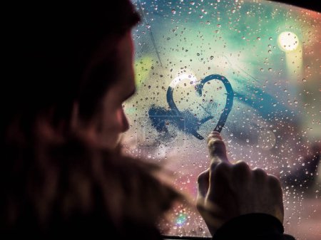 Téléchargez les photos : L'homme amoureux dessine le cœur sur la fenêtre - en image libre de droit