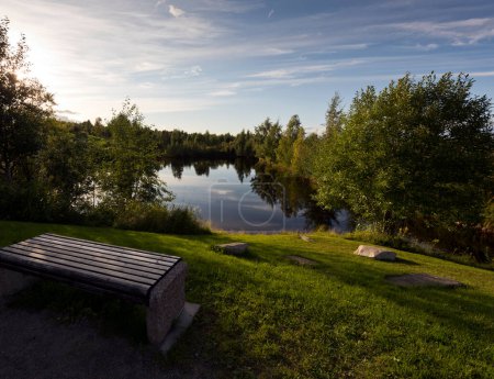 Téléchargez les photos : "Un banc au bord de l'eau le soir. Finlande
" - en image libre de droit