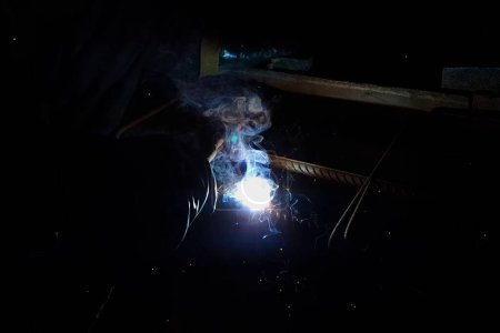 Photo for "Welding of steel reinforcement. Sparks and light from welding. Electric welding" - Royalty Free Image