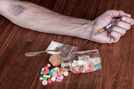 Téléchargez les photos : Toxicomane dans une héroïne, une seringue et une héroïne sur une table en bois - en image libre de droit