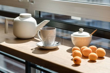 Téléchargez les photos : Théière, tasse et bol à sucre en céramique près des abricots - en image libre de droit
