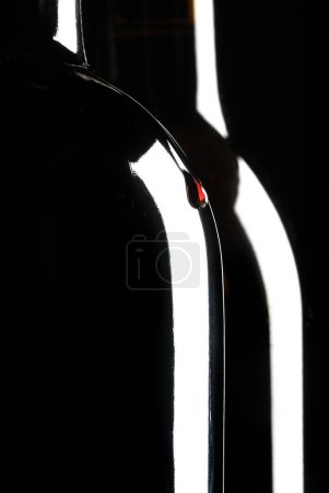 Foto de Dos botellas de vino, gota de vino, fondo negro - Imagen libre de derechos