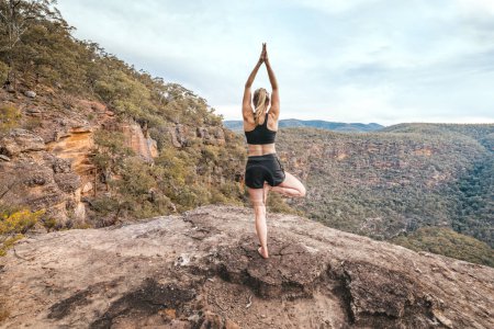 Photo for Female strength yoga balance asana mountain cliff ledge - Royalty Free Image