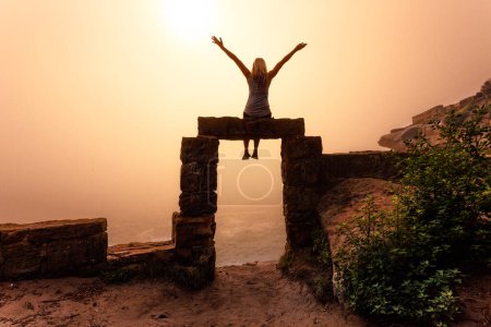 Photo for Female sits on top of doorway to the unknown realm - Royalty Free Image