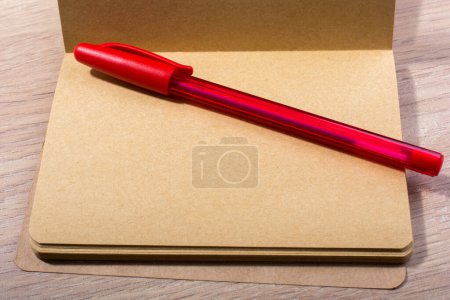 Foto de "Cuaderno abierto color marrón y un bolígrafo
" - Imagen libre de derechos