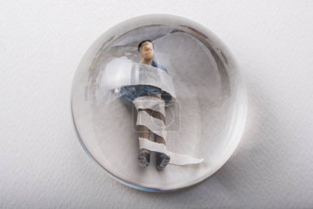 Téléchargez les photos : "Minuscule figurine enveloppée du modèle homme sous loupe" - en image libre de droit