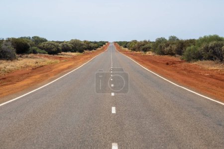 Foto de Long straight road leading through dry Australian Bush land - Imagen libre de derechos