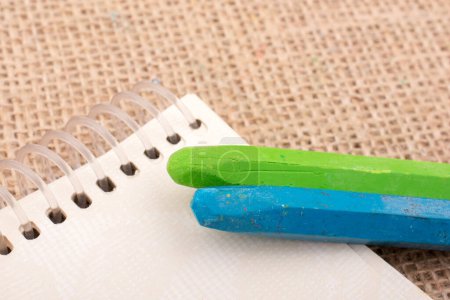 Foto de "Lápices de colores colocados en un cuaderno
 " - Imagen libre de derechos
