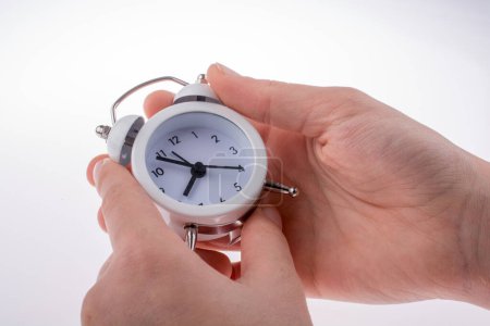 Photo for Alarm clock in woman hand over white background - Royalty Free Image