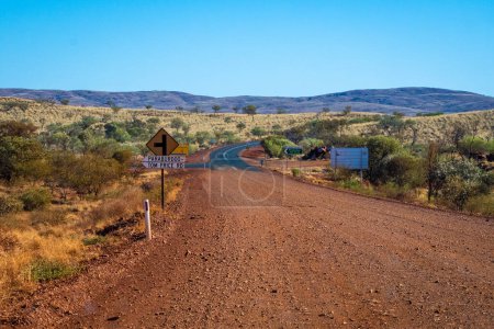 Téléchargez les photos : "Frontière entre gravier et route asphaltée dans l'ouest de l'Australie Parc national Karijini près de Tom Price" - en image libre de droit