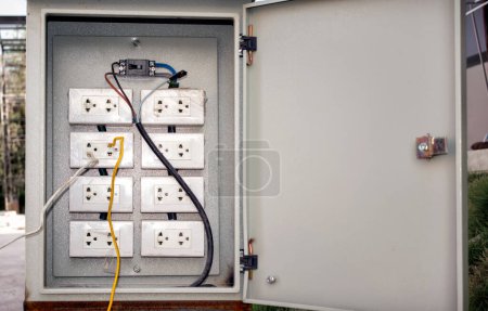 Foto de "Conexiones eléctricas peligrosamente cableadas en una caja de interruptores." - Imagen libre de derechos