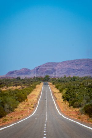 Foto de "Largo camino vacío en Australia Occidental que conduce hacia el Parque Nacional Karijini" - Imagen libre de derechos