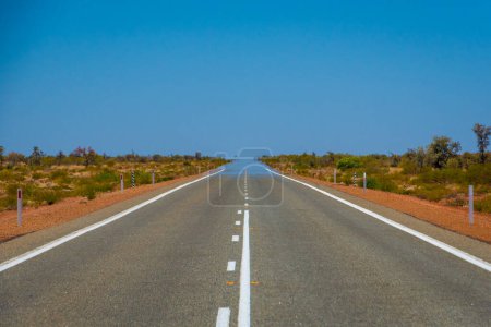 Téléchargez les photos : "Mirage sur route droite sans fin en Australie fusionnant asphalte et ciel" - en image libre de droit