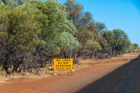 Photo for "No lines do not overtake unless safe sign in road work area on Australian road" - Royalty Free Image