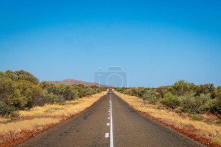 Téléchargez les photos : "Minerai de fer rouge et violet poussière à côté de la route au parc national Karijini Australie" - en image libre de droit