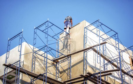 Photo for "Apartment Building being Constructed with No Safety Equipment for Workers." - Royalty Free Image