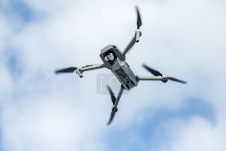 Photo for "the quadcopter of gray color with the camera in flight against" - Royalty Free Image