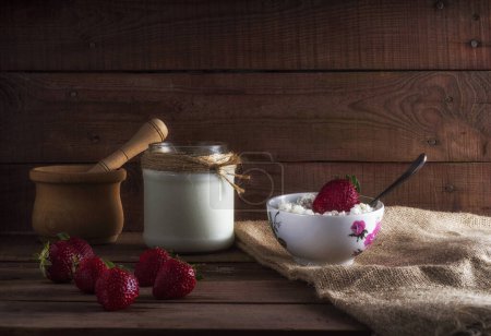 Photo for "Tvorog, farmers cheese, curd cheese or cottage cheese in bowl with fresh strawberry." - Royalty Free Image