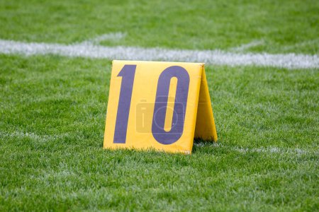 Téléchargez les photos : "American Football 10 yard marqueur sur l'herbe par la ligne" - en image libre de droit