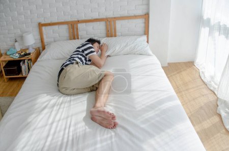 Téléchargez les photos : Asiatique homme sommeil dans lit - en image libre de droit