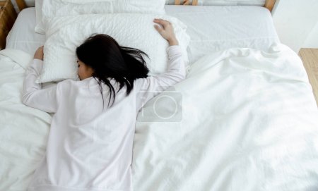 Téléchargez les photos : Asiatique femme dormir dans blanc lit - en image libre de droit