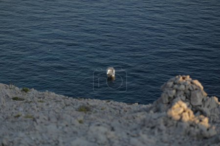 Photo for Small launch boat with people, blue sea, rocky coast - Royalty Free Image