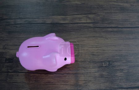Photo for Top view of pink piggy bank on wooden background - Royalty Free Image