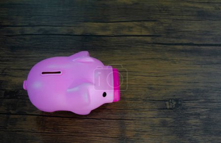 Photo for Pink piggy bank on wooden table - Royalty Free Image