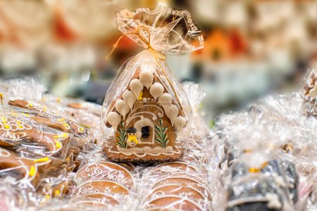Téléchargez les photos : "Maison de pain d'épice de Noël fait maison exposée sur une table. Maison de pain d'épice emballée. Beaucoup de maisons en pain d'épice
." - en image libre de droit